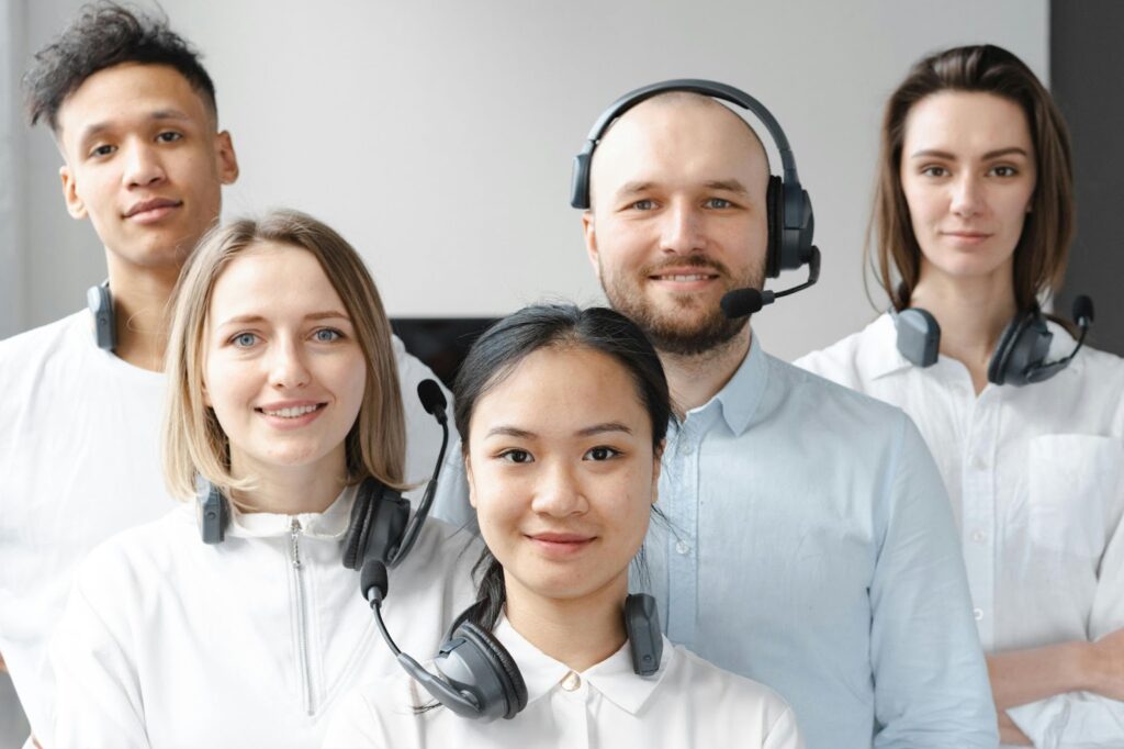How Customer Service AI Agents Are Redefining Support Efficiency 2
A close-up shot of a diverse team of five customer service agents wearing headsets, smiling confidently while looking at the camera.