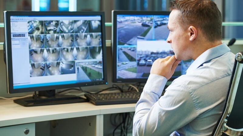 The Tech-Driven Shield: How AI and Real-Time Data are Disrupting Criminal Activity 1 A law enforcement officer in a high-tech command center monitoring multiple real-time surveillance feeds and data analytics dashboards to track urban activity.