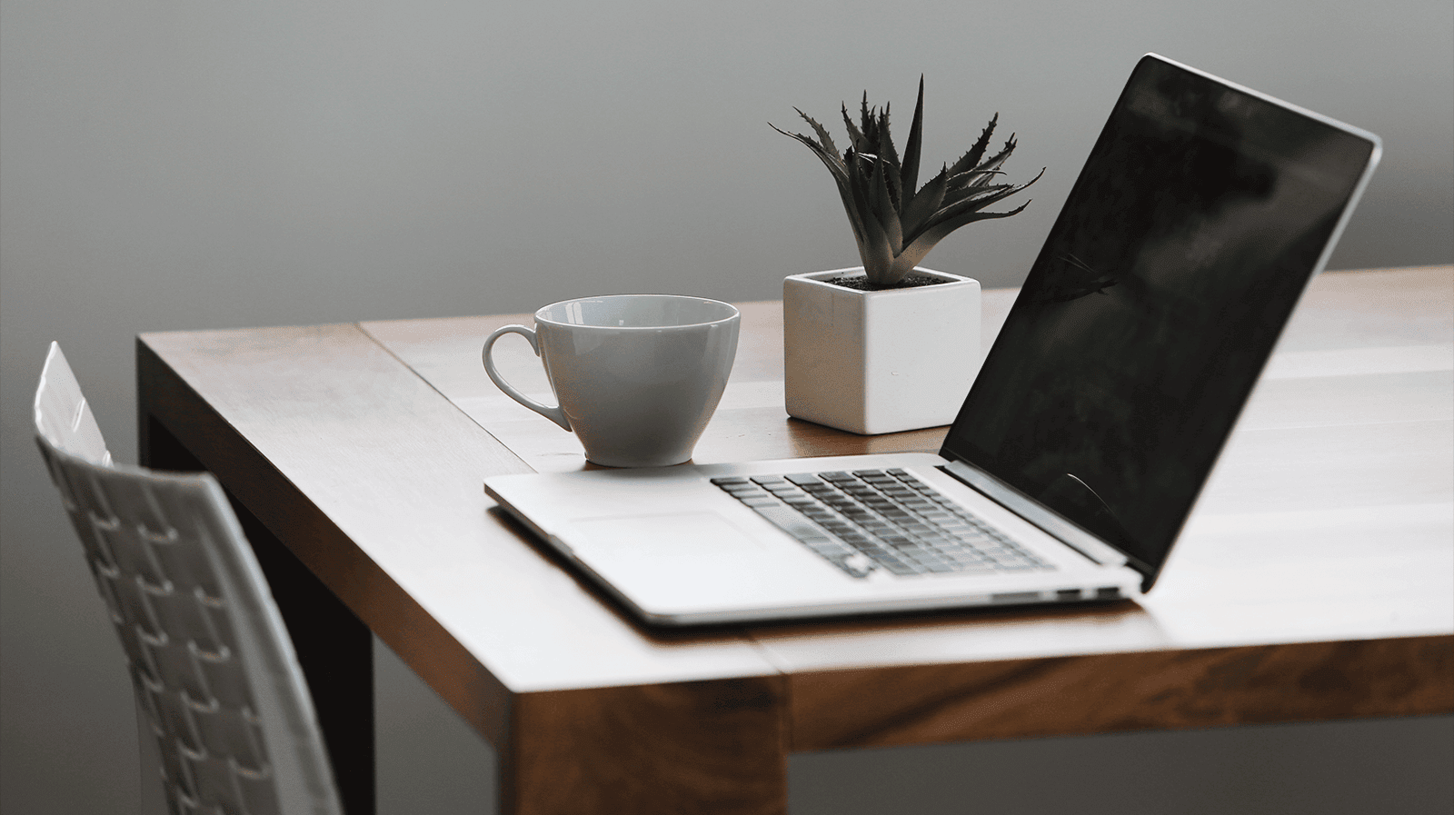 mac compture and a cup on top of table
