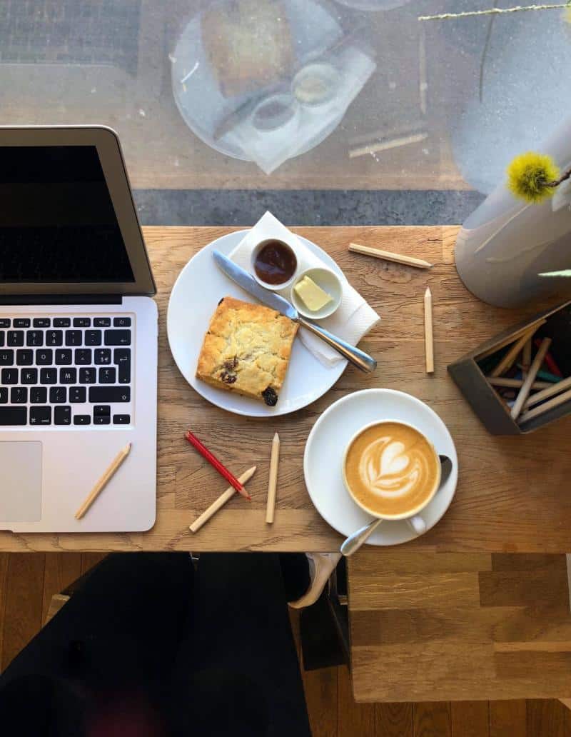 macbook_air_turned_off_beside_plate_with_bread_knife_and_dip_on_plate-scopio