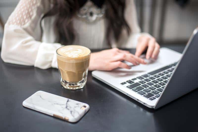 person_holding_silver_iphone_6_near_macbook_pro-scopio -b2b content-marketing